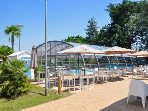 a group of tables and umbrellas next to a pool at Novotel Nantes Carquefou in Carquefou