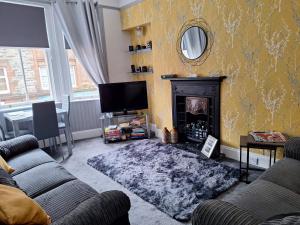 a living room with a fireplace and a tv at The Nifty Nook in Campbeltown