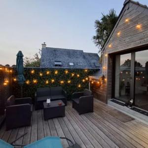 a patio with couches and lights on a building at Gîte La Terrasse du 37 in Breteil