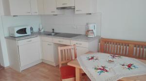 a small kitchen with a table and a microwave at Arche Hof Bichler in Gais