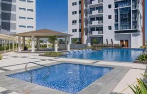 a swimming pool in front of a building at Mactan Daily Staycation in Punta Engaño