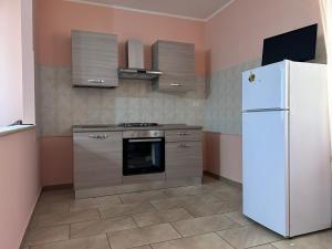 a kitchen with a white refrigerator and a stove at Villa Vanessa in Spoltore
