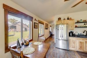 a kitchen with a table and a refrigerator at On the Flathead River! Rustic Saloon-Themed Cabin in Columbia Falls