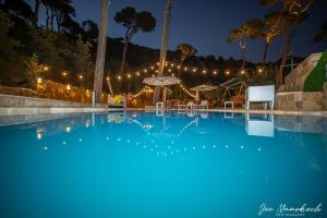 a large swimming pool at night with lights at Beel Hills in Khallat al Mutayn