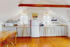 a kitchen with a white refrigerator in a room at Charming cottage close to the beach in Truro