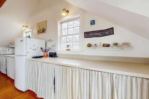 a kitchen with a large counter with a refrigerator at Charming cottage close to the beach in Truro