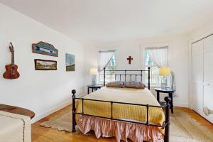 a bedroom with a bed and a cross on the wall at Charming cottage close to the beach in Truro +10 photos