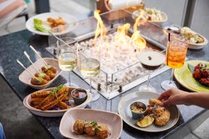 a table with plates of food and glasses of wine at The Tower Hotel, by Thistle in London