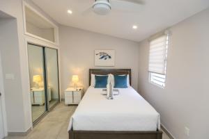 a bedroom with a large bed with blue pillows at 246D South Finger in Jolly Harbour +20 photos