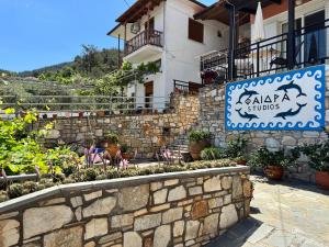 a stone wall with a sign in front of a building at Studios Fedra in Potamiá