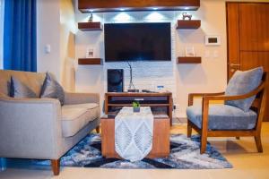 a living room with two couches and a tv at Mactan Daily Staycation in Punta Engaño