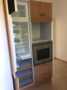 a kitchen with an empty refrigerator and a microwave at Rosenwohnung in Neustrelitz