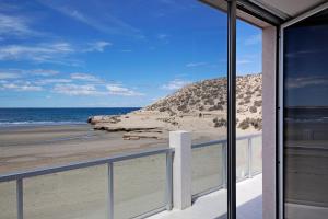 
a view from a balcony of a beach with a view of the ocean at Oceano Patagonia Wild Coast Residence in Puerto Pirámides
