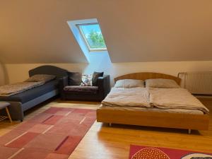 a bedroom with a bed and a couch and a window at Ubytovanie pri lese a vode in Hamuliakovo