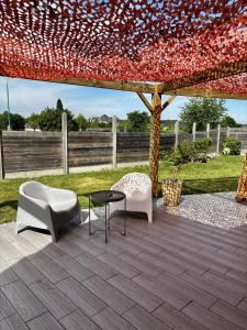 a patio with two chairs and a table under a tent at Hôtel Le Pavillon de Saint-Lô in Saint Lo