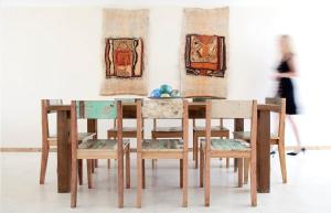 einen Tisch und Stühle mit Gemälden in einem Zimmer in der Unterkunft Oceano Patagonia in Puerto Pirámides