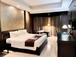 a hotel room with a bed and a desk at Napalai Hotel in Udon Thani