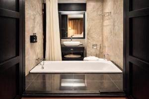 a bathroom with a large tub and a sink at Napalai Hotel in Udon Thani