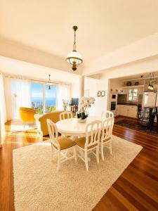 a living room with a white table and chairs at A Velha Casa Caboz in Ponta do Sol