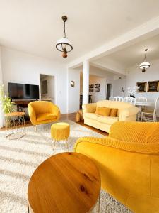 a living room with yellow furniture and yellow chairs at A Velha Casa Caboz in Ponta do Sol