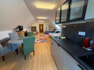 a kitchen and living room with a table and chairs at Ubytovanie pri lese a vode in Hamuliakovo +4 photos