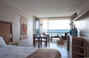 1 dormitorio con cama y vistas al océano en Oceano Patagonia by Nordic en Puerto Pirámides