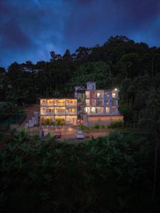 a building with lights on in a parking lot at Sky Dale Pool Resort Munnar in Munnar