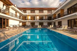 a pool at a hotel with chairs and tables at Anne's Hotel in Mestia in Mestia