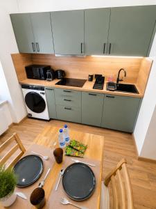 a kitchen with a table and a sink and a stove at L'Escale Strasbourgeoise climatisée in Strasbourg