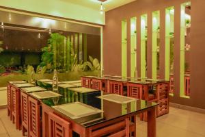 a dining room with tables and an aquarium at Sky Dale Pool Resort Munnar in Munnar