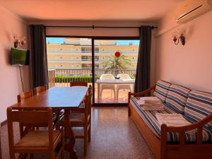 a living room with a table and a couch and a window at Payet Apartments in L'Estartit