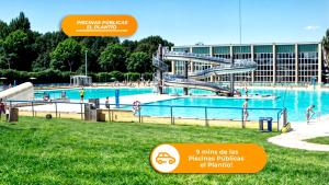 a swimming pool with a water slide in front of a building at La Casa de los Inventos in Burgos
