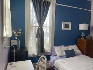 a blue bedroom with a bed and a window at B-Love's Guest House in Oakland