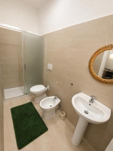 a bathroom with a sink and a toilet and a mirror at Alba Mediterranea in Reggio di Calabria