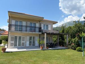 a house with a balcony and a yard at Vila CarpeDiem in Herceg-Novi