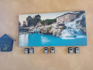 a picture hanging on a wall with a picture of a waterfall at B&B 8380 Saturnia Terme in Saturnia