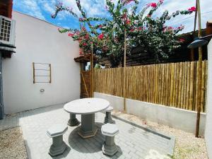 a picnic table in a patio with a fence at Jardim dos Milagres Suítes in São Miguel dos Milagres