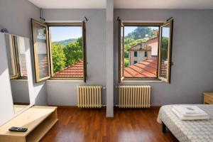 a room with two windows and a bed and a view at Hotel Degli Angeli in Pontinvrea