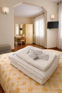 a bedroom with a bed with a white blanket at Hotel Degli Angeli in Pontinvrea