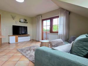 a living room with a couch and a television at Ferienwohnung Matheaperle mit Infrarotkabine in Nidda +65 photos