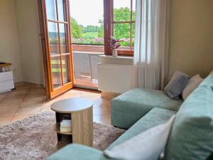 a living room with a couch and a table and a window at Ferienwohnung Matheaperle mit Infrarotkabine in Nidda