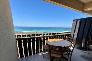a table and chairs on a balcony with the ocean at Lacanau-Océan Triplex Front de mer in Lacanau-Océan