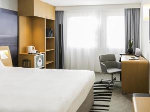 a hotel room with a bed and a desk and a chair at Novotel Strasbourg Centre Halles in Strasbourg +99 photos