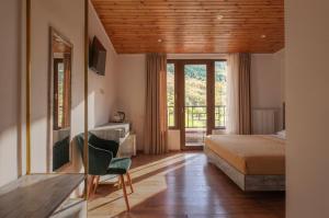 a bedroom with a bed and a desk with a chair at Anne's Hotel in Mestia in Mestia +58 photos