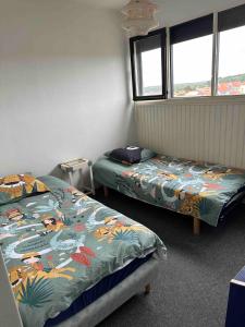 a room with two beds and two windows at Lacanau-Océan Triplex Front de mer in Lacanau-Océan