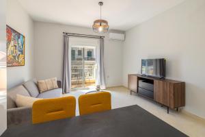 a living room with a couch and a tv at Blue Skala - Indigo Apartment I in Skala