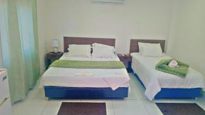 a bedroom with two beds with towels on them at Hospedaje Alexa in Asunción