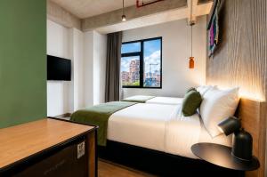 a hotel room with a bed and a window at Hunters Hotel Medellin in Medellín