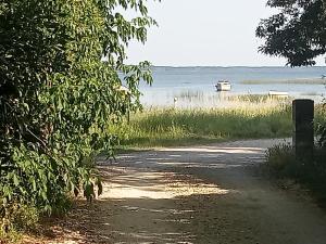 a dirt road with a boat in the water at Villa René in Lacanau