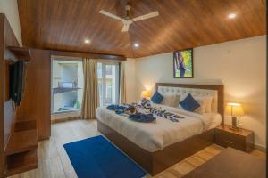 a bedroom with a large bed with a ceiling fan at Mango Bloom River Resort By Excel Hotels & Resorts in Marchula